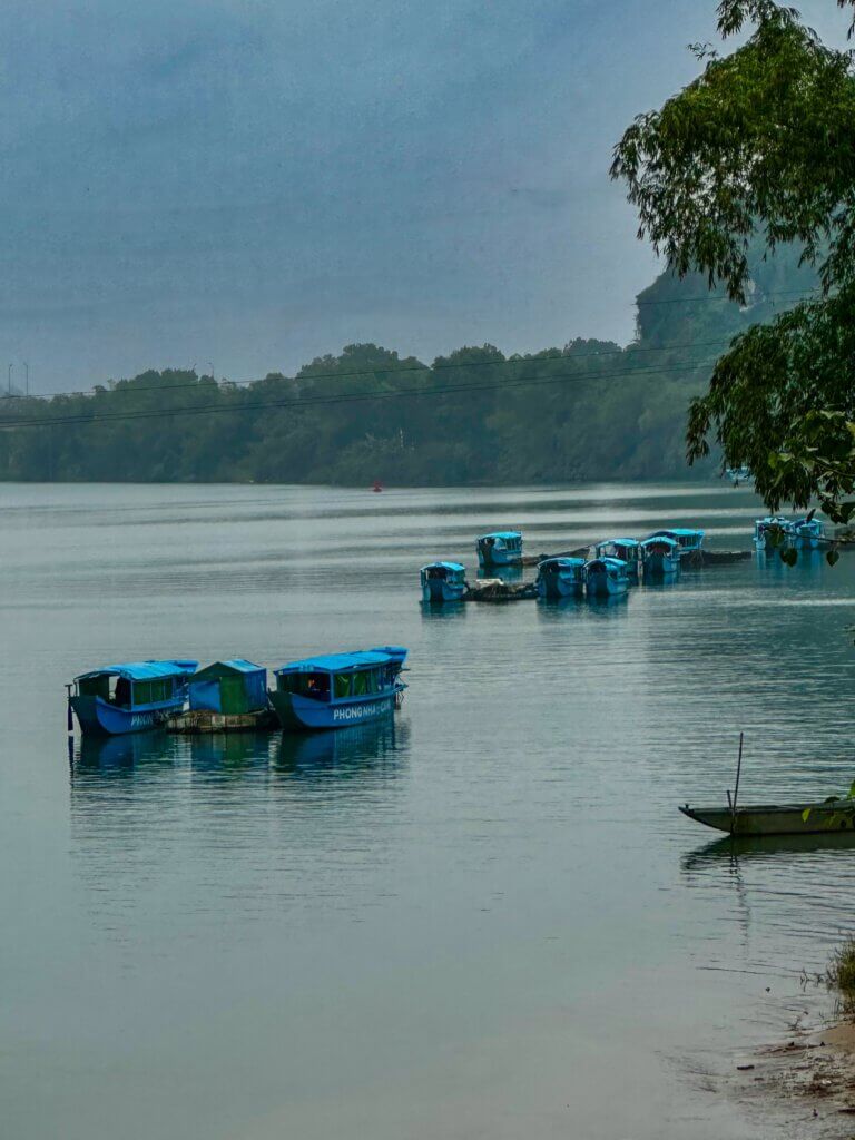 Boote mit blauen Planen an der Anlegestelle von Son Trach im Phong Nha-Kẻ Bàng Nationalpark, Ausgangspunkt für Höhlentouren in Vietnam