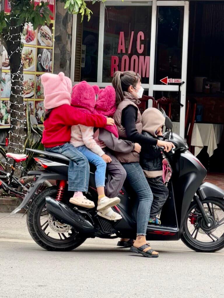 Straßenszene in Tam Coc, Vietnam: Familie mit Kindern auf einem Motorroller unterwegs