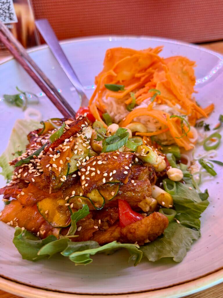 Frisches vietnamesisches Gericht mit Sesam-Hähnchen, Reisnudeln, Karotten und Erdnüssen im Restaurant Monsieur Vuong in Berlin-Mitte
