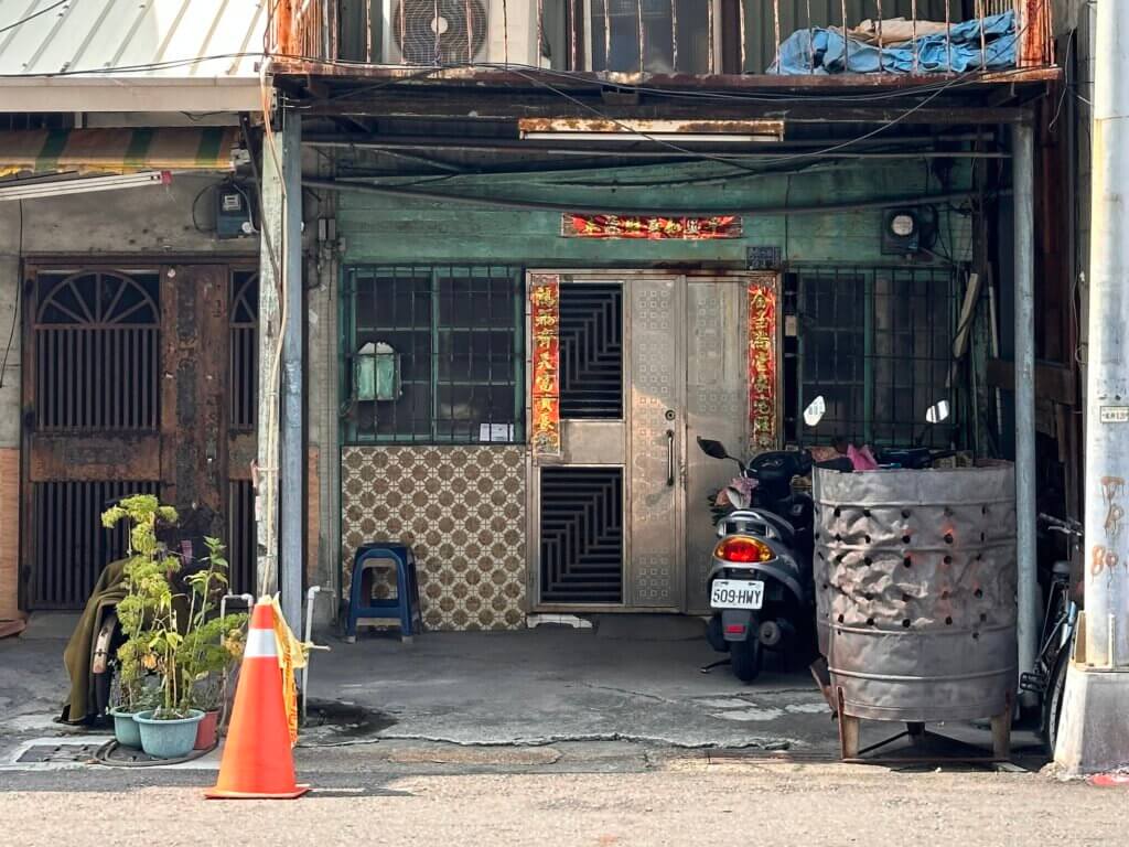 Straßenszene mit Hausfront, Motorroller und Pflanzkübeln in Kaohsiung – Taiwan Rundreise