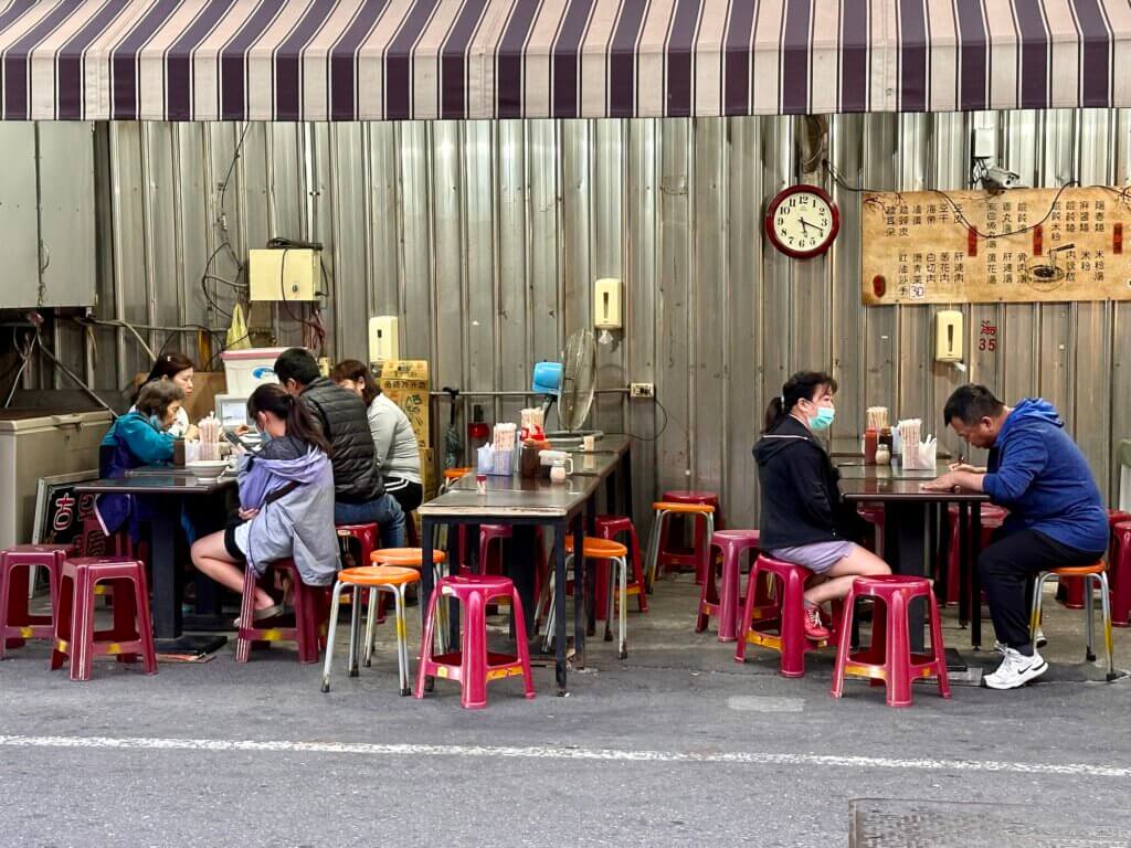 Straßenszene mit Gästen an Tischen in einem einfachen Restaurant in Lukang, Taiwan – Taiwan Rundreise