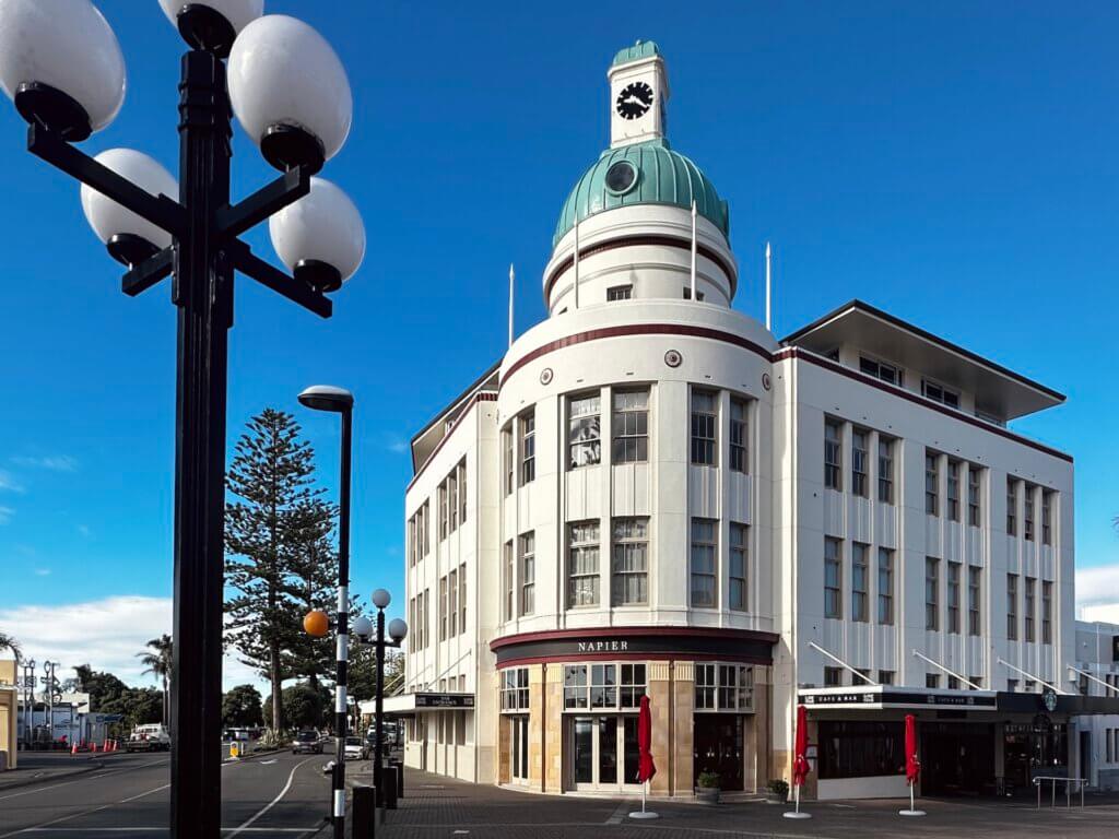 T&G Building in Napier im Art-Déco-Stil bei blauem Himmel, mit Straßenlaterne im Vordergrund.